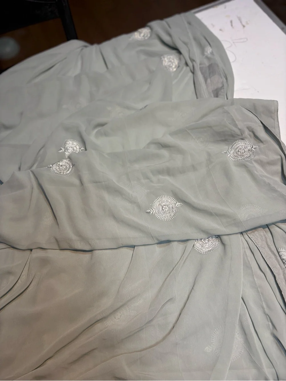 218” Legnth sage green draped saree features delicate silver embroidery